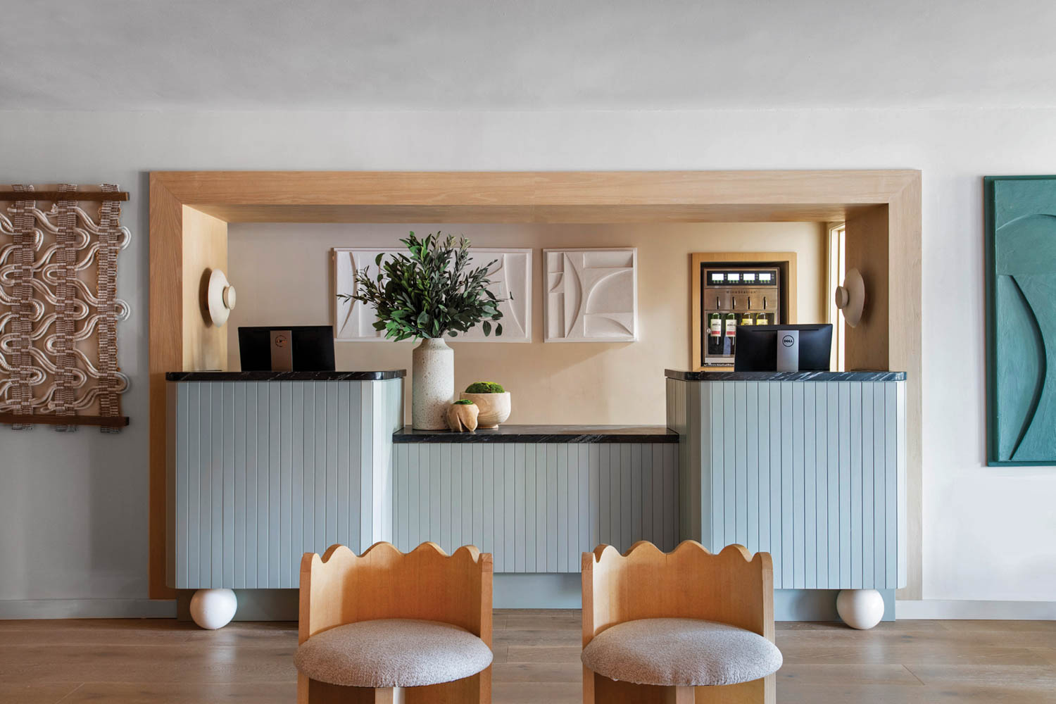 scalloped chairs and a blue reception counter at Hotel Avante
