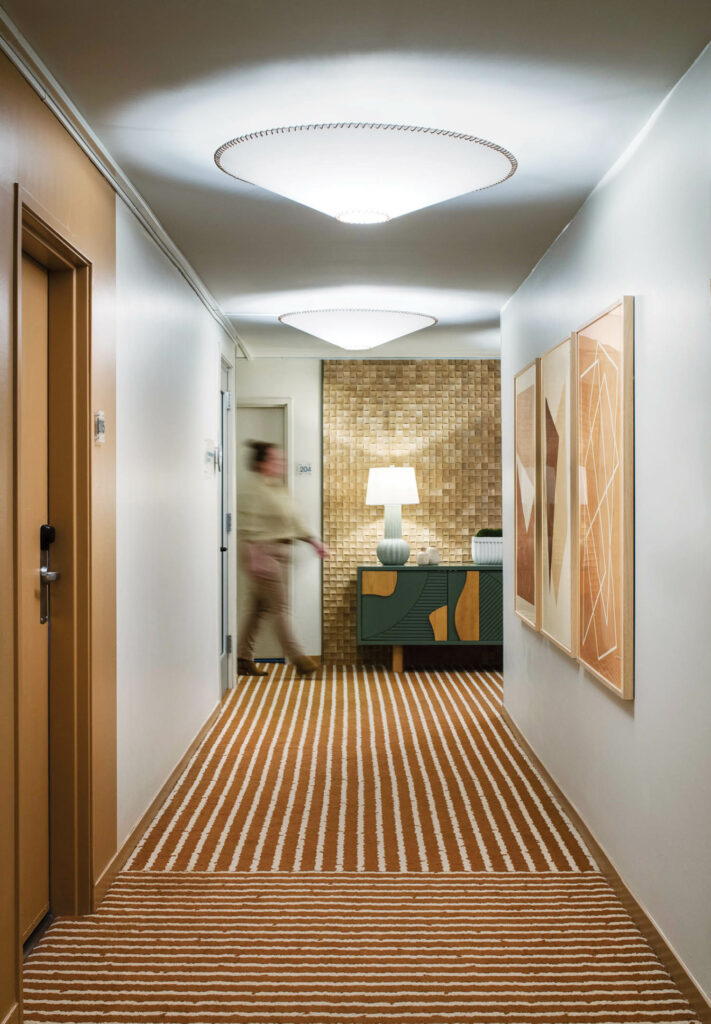a hallway with striped orange and white carpeting at Hotel Avante