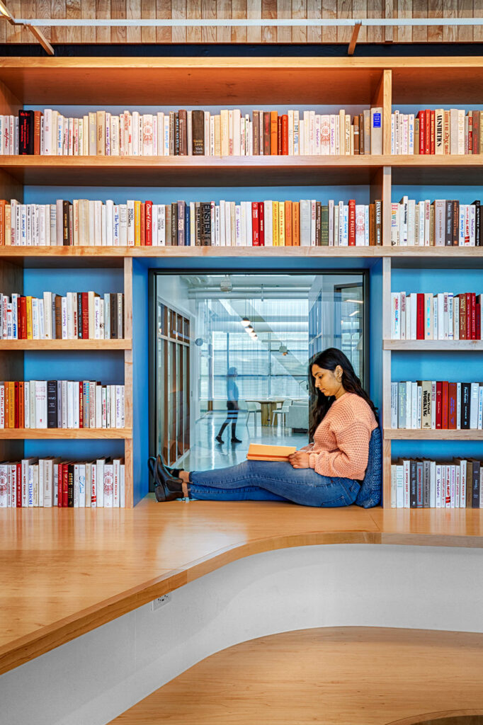 a woman reading surrounded by a wall of books