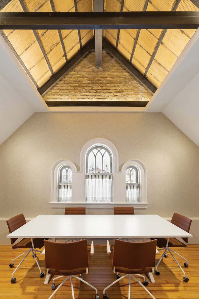 Meeting room and flexible space in older museum with original vaulted ceiling and supports visible
