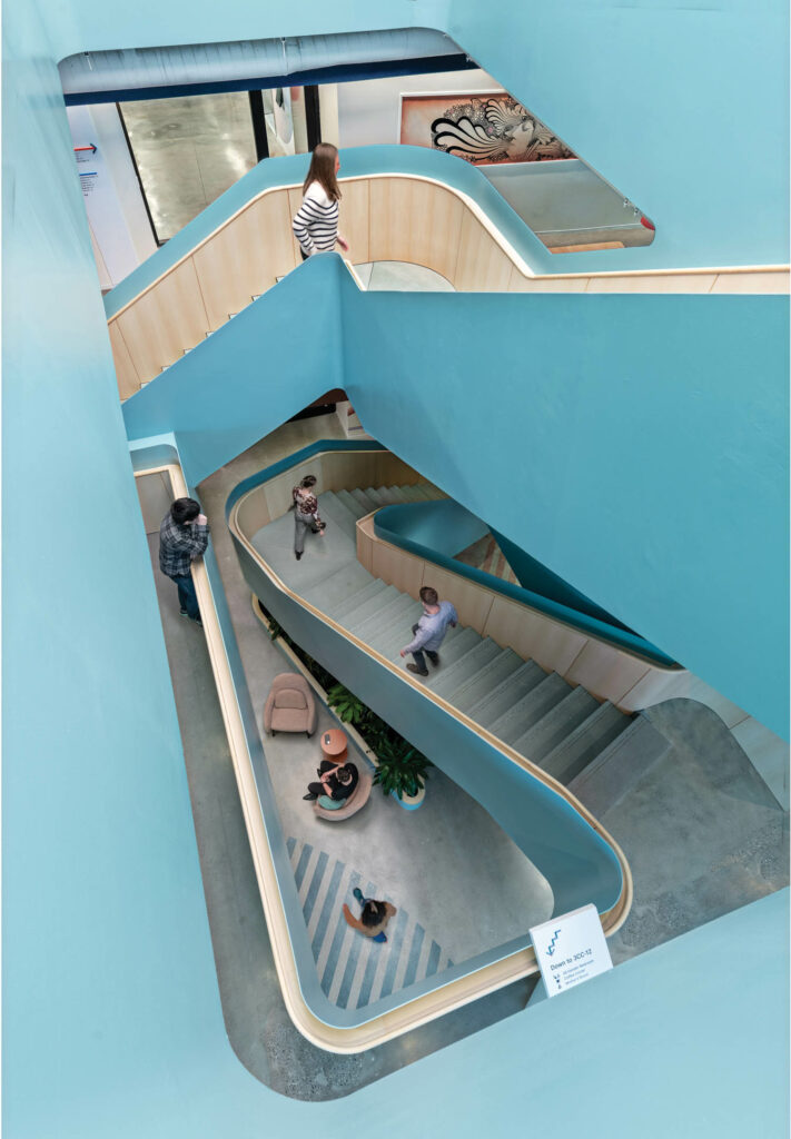 a person walks down a staircase with sky blue walls