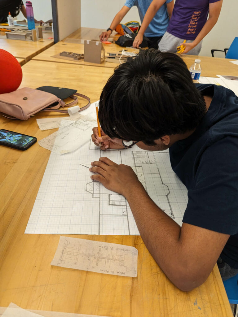 a student works on design drawings at Design Your World St. Louis