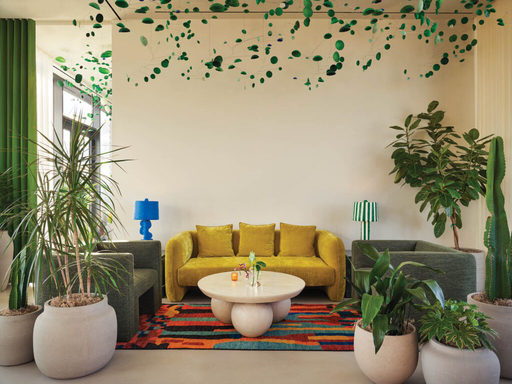 a green ceiling installation hangs above a common area in Penny Williamsburg