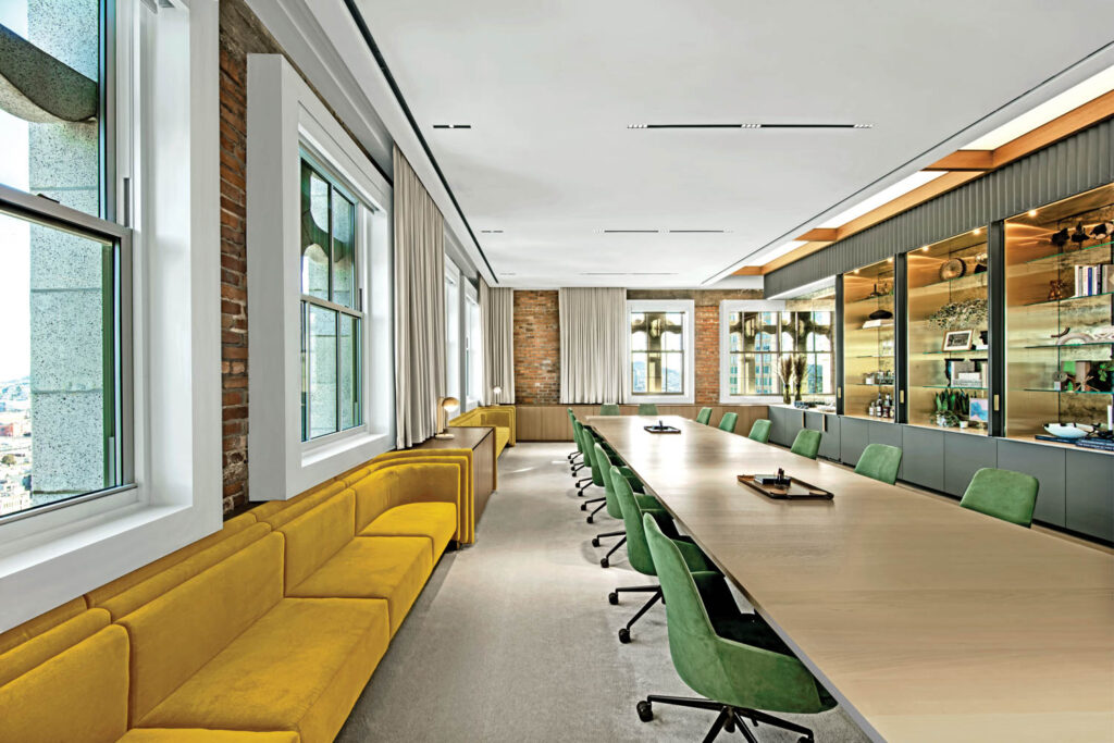 conference room with yellow benches and green chairs at table