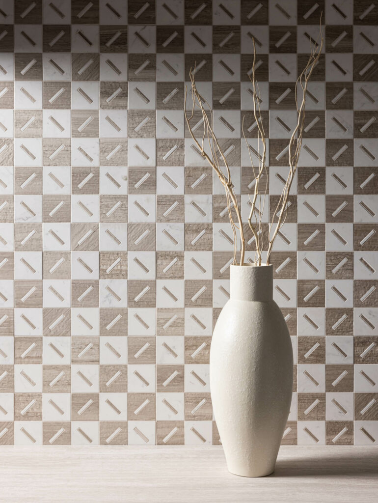 brown and white tile on the wall with a vase in front of it