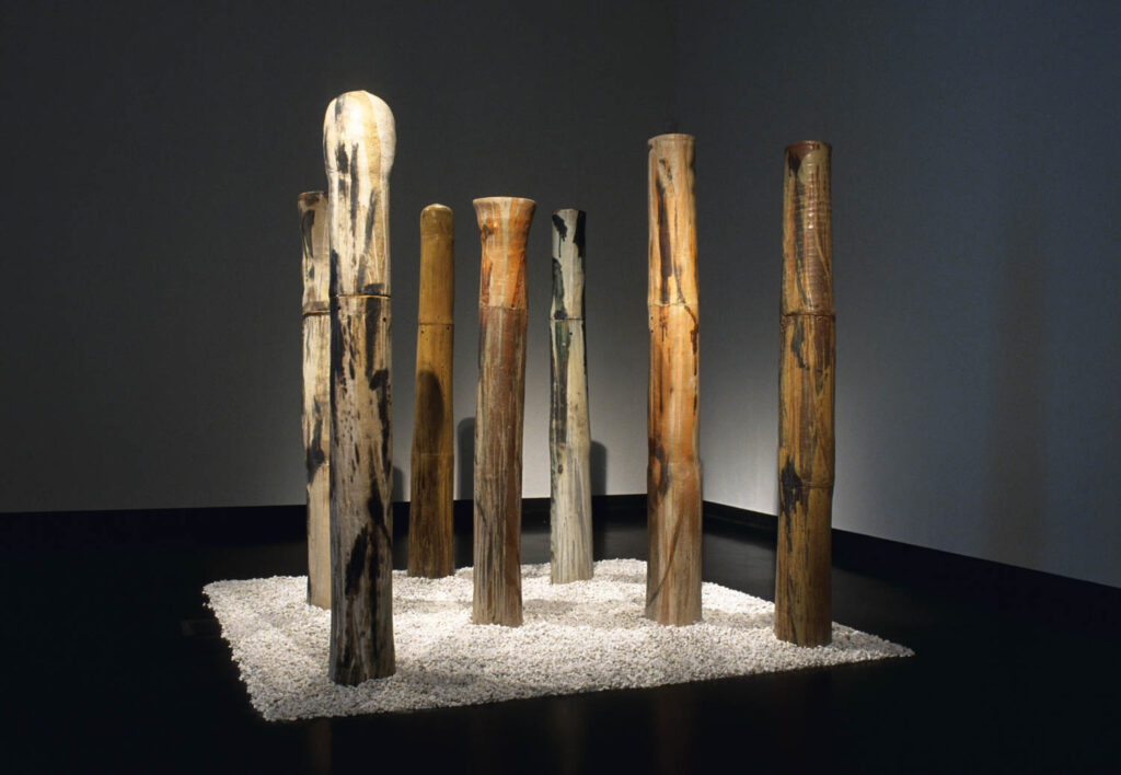 installation view of multiple bamboo sticks on a platform