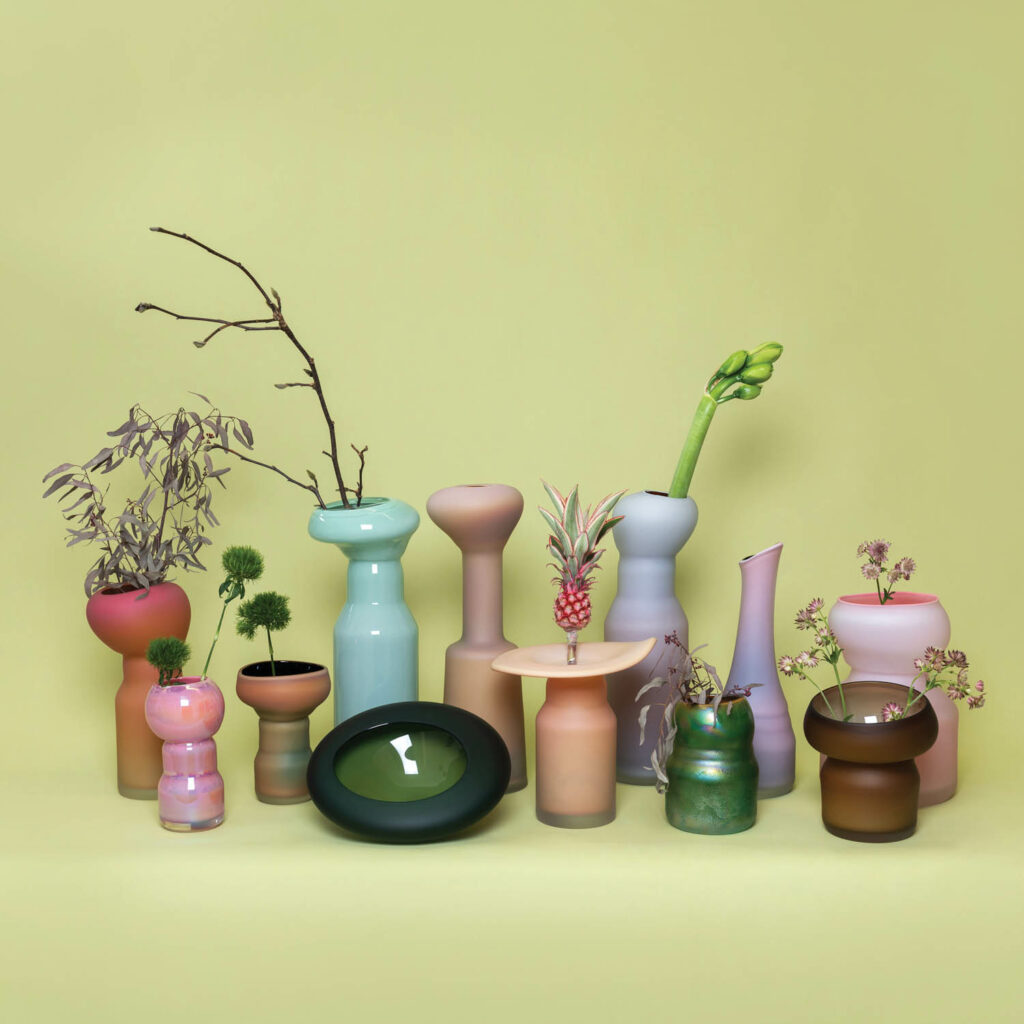 different handcrafted glass vessels inspired by mushrooms against green backdrop