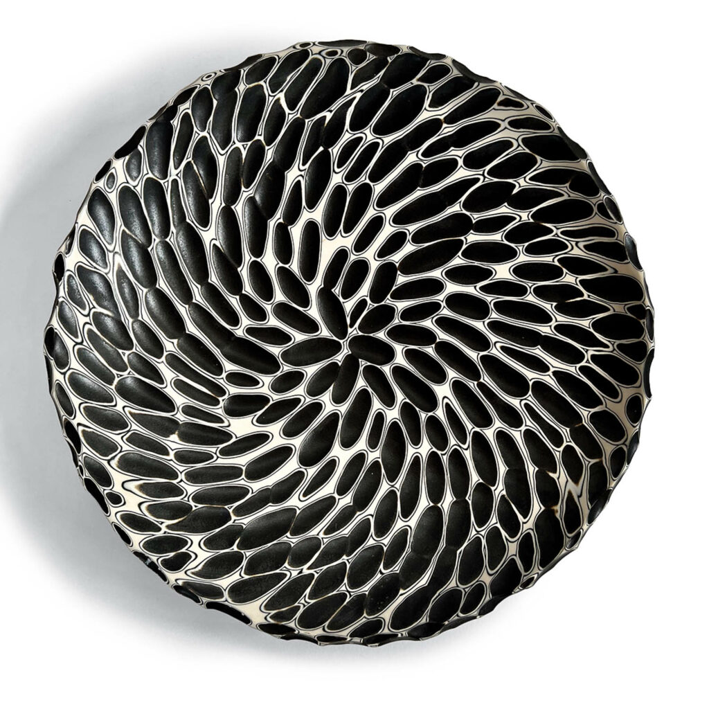 black plate patterned with pinecone-like spirals