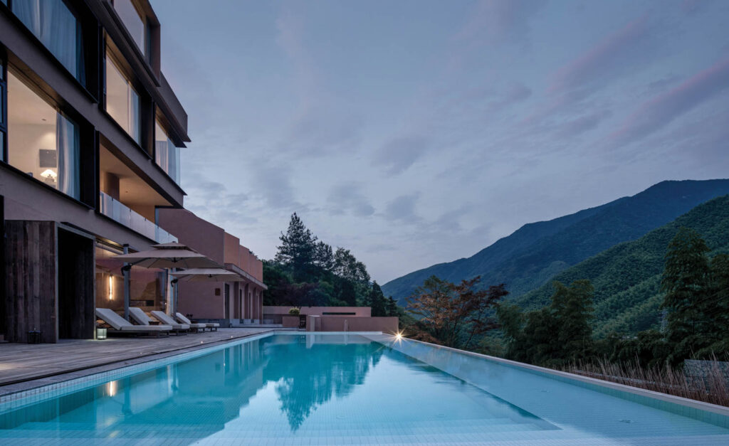 outdoor pool with a view of the mountains and the resort rooms